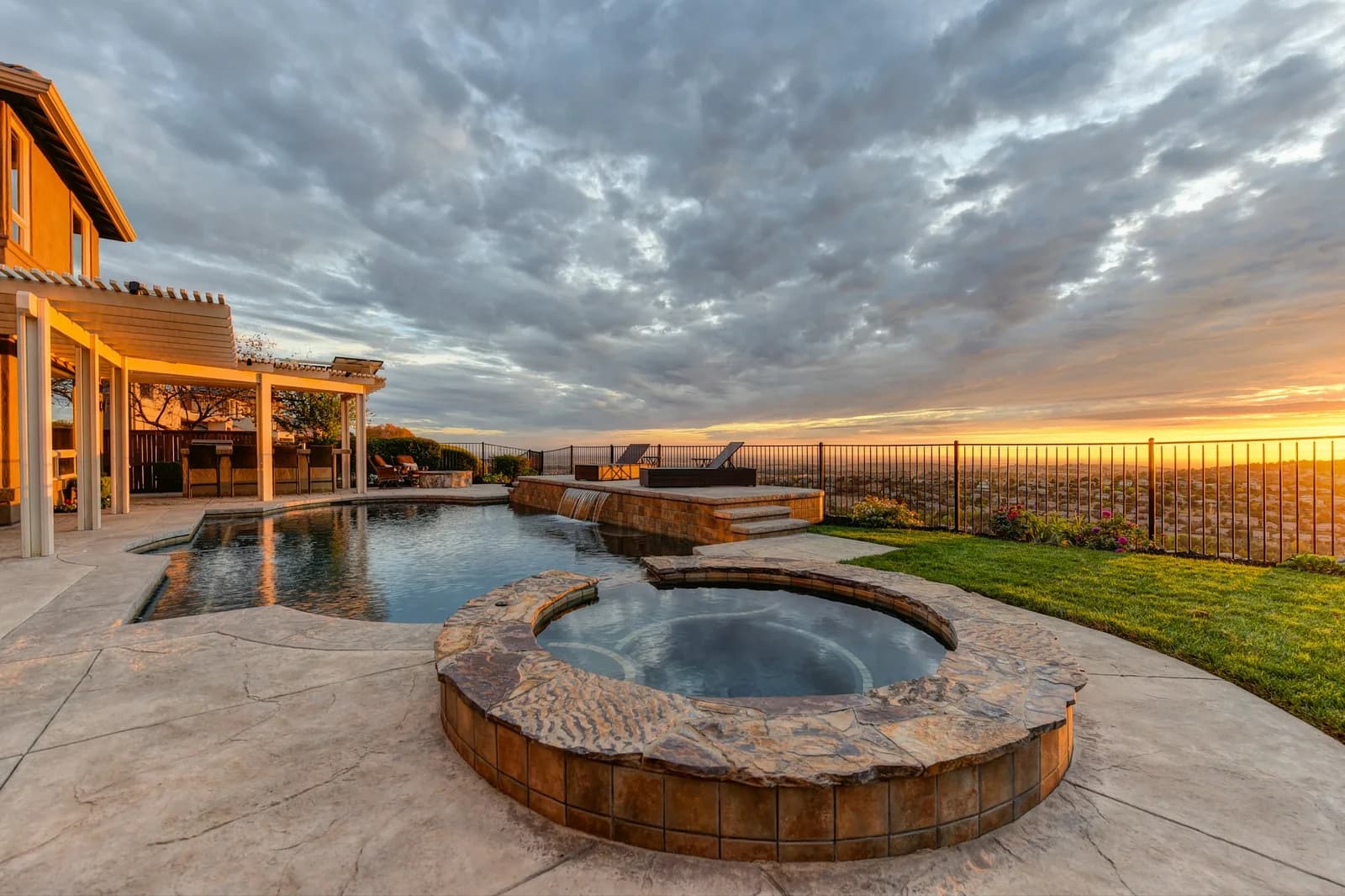 Illustrative outdoor hot tub beside a pool at sunset