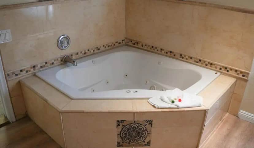 a large bath tub in a bathroom with a towel at 777 Motor Inn in Sherman Oaks