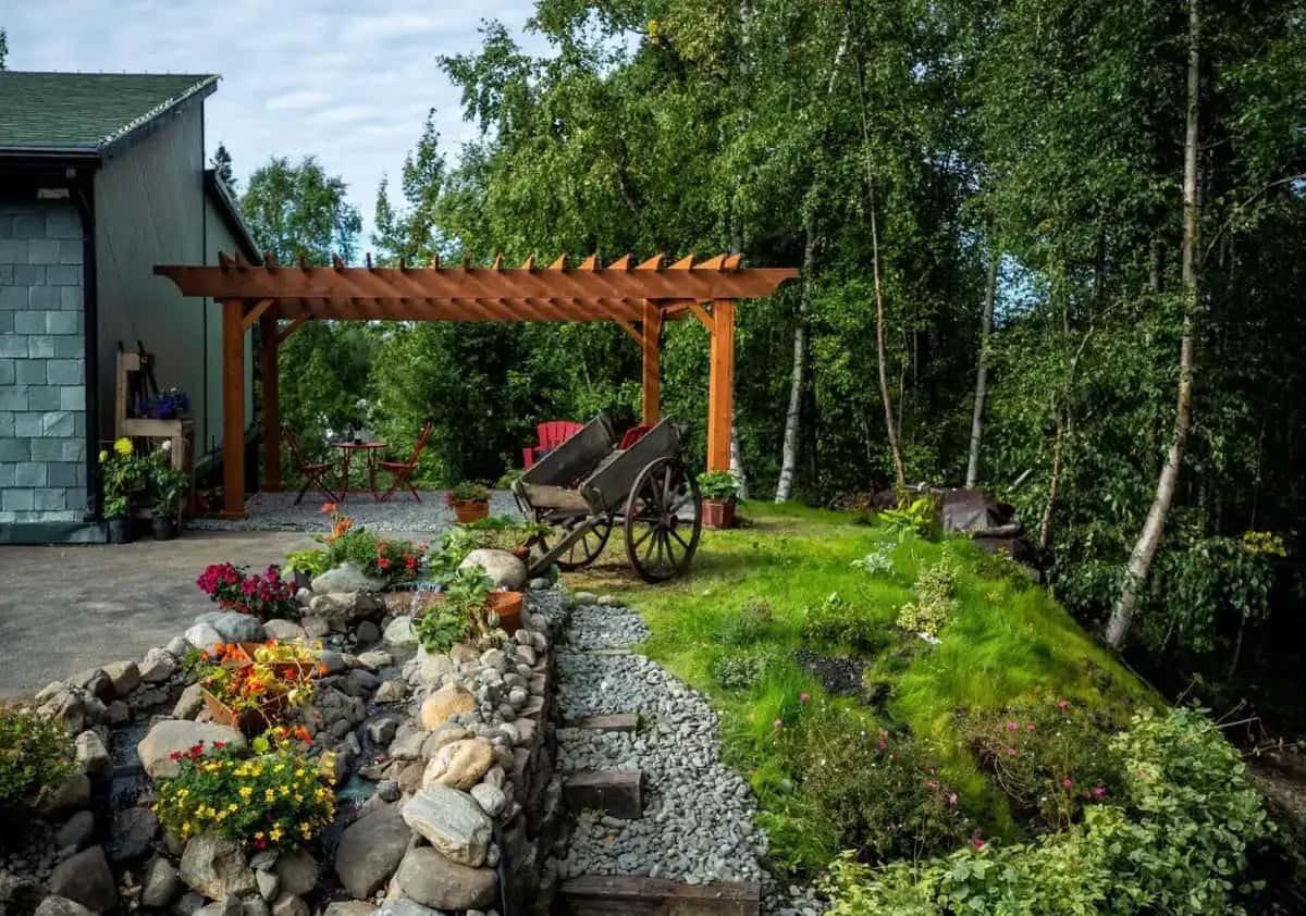 a garden with a bench and a wooden pergola at Alaska House of Jade Bed and Breakfast in Anchorage