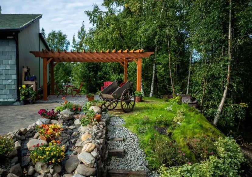 a garden with a bench and a wooden pergola at Alaska House of Jade Bed and Breakfast in Anchorage