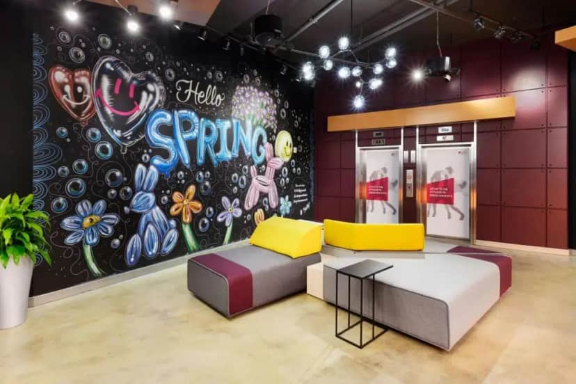 a room with a couch and a wall with a mural at Aloft by Marriott Greenville Downtown in Greenville