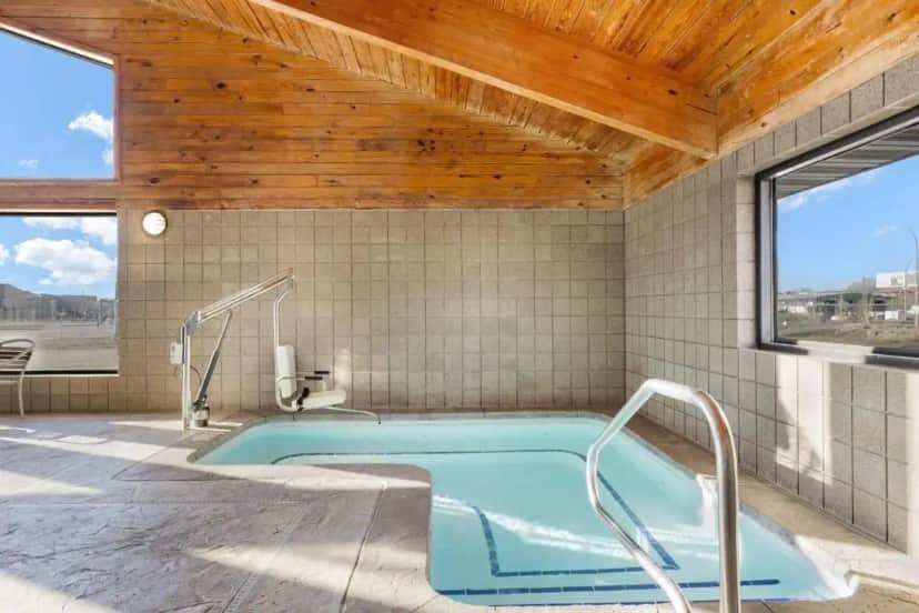 a hot tub in a room with a wooden ceiling at AmericInn by Wyndham Bismarck in Bismarck