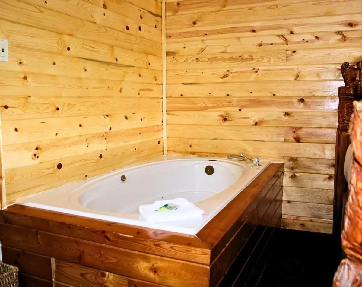 a bath tub in a room with wooden walls at Angler's Lodge in Island Park