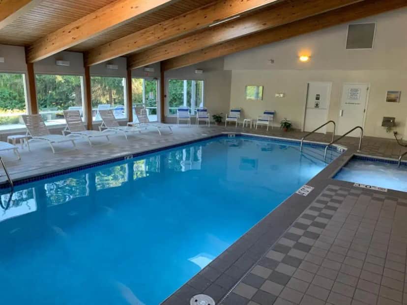 a large swimming pool with chairs and tables in a building at AppleCreek Resort-Hotel & Suites in Fish Creek