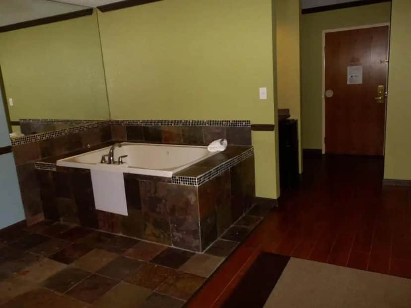 a bath tub in a room with green walls at Araamda Inn in Norcross