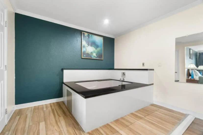 a bathroom with a sink and a green wall at Aristocrat Motel in Baldwin Park
