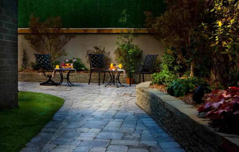 a patio with two tables and chairs in a garden at Aura Hotel Brooklyn in Brooklyn