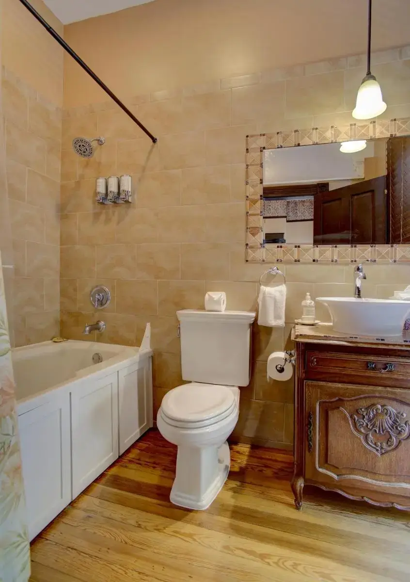 a bathroom with a toilet and a tub and a sink at Azalea Inn and Villas in Savannah