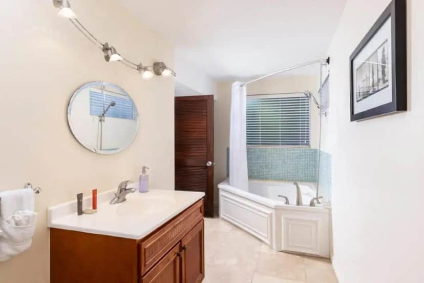 a bathroom with a sink and a tub and a mirror at Azul del Mar in Key Largo