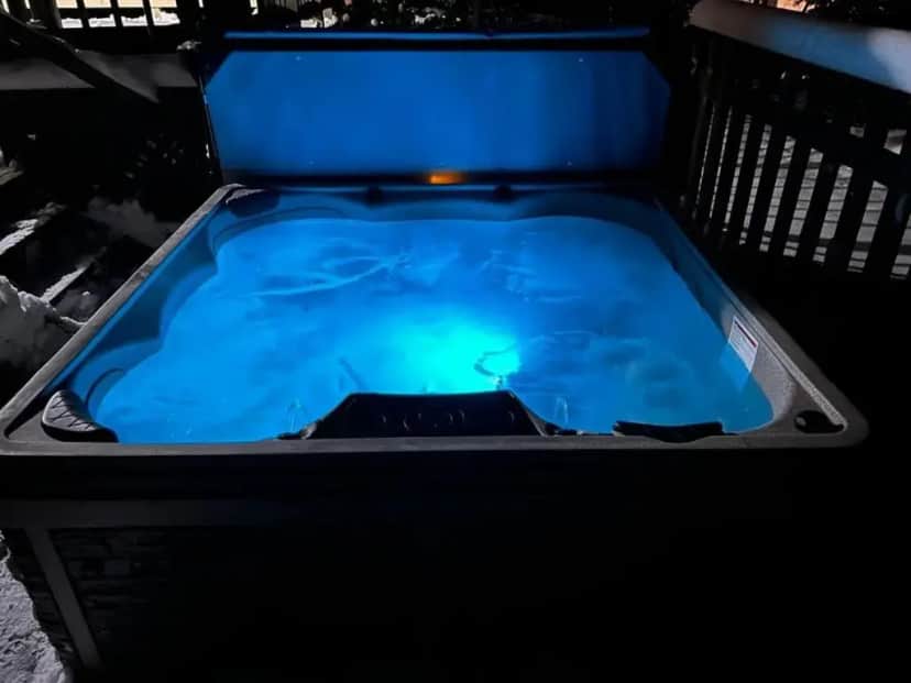 a hot tub with a blue liquid in it at BASS LAKE RETREAT- lakeview home w 5 Bedrooms, Hot Tub, Game room, Pets in Traverse City