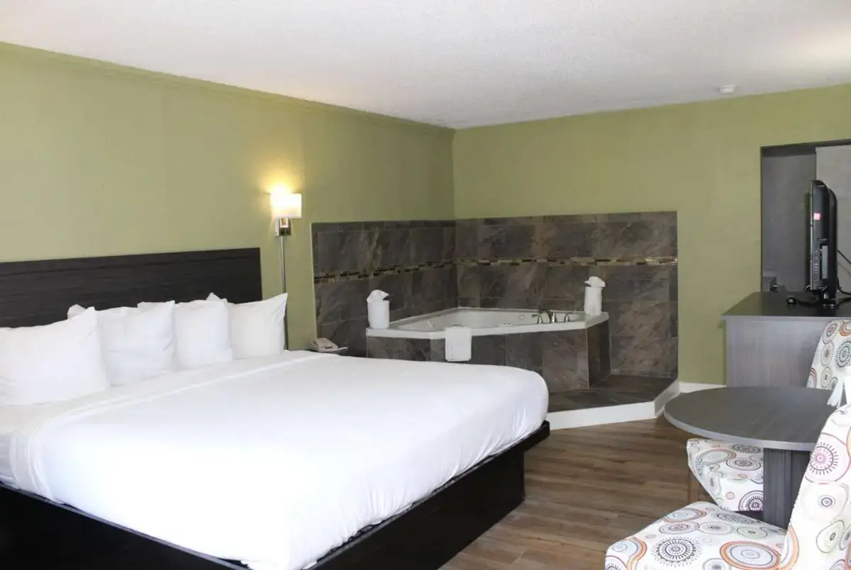 a hotel room with a bed and a bath tub at Baymont by Wyndham Front Royal Near Shenandoah National Park in Front Royal