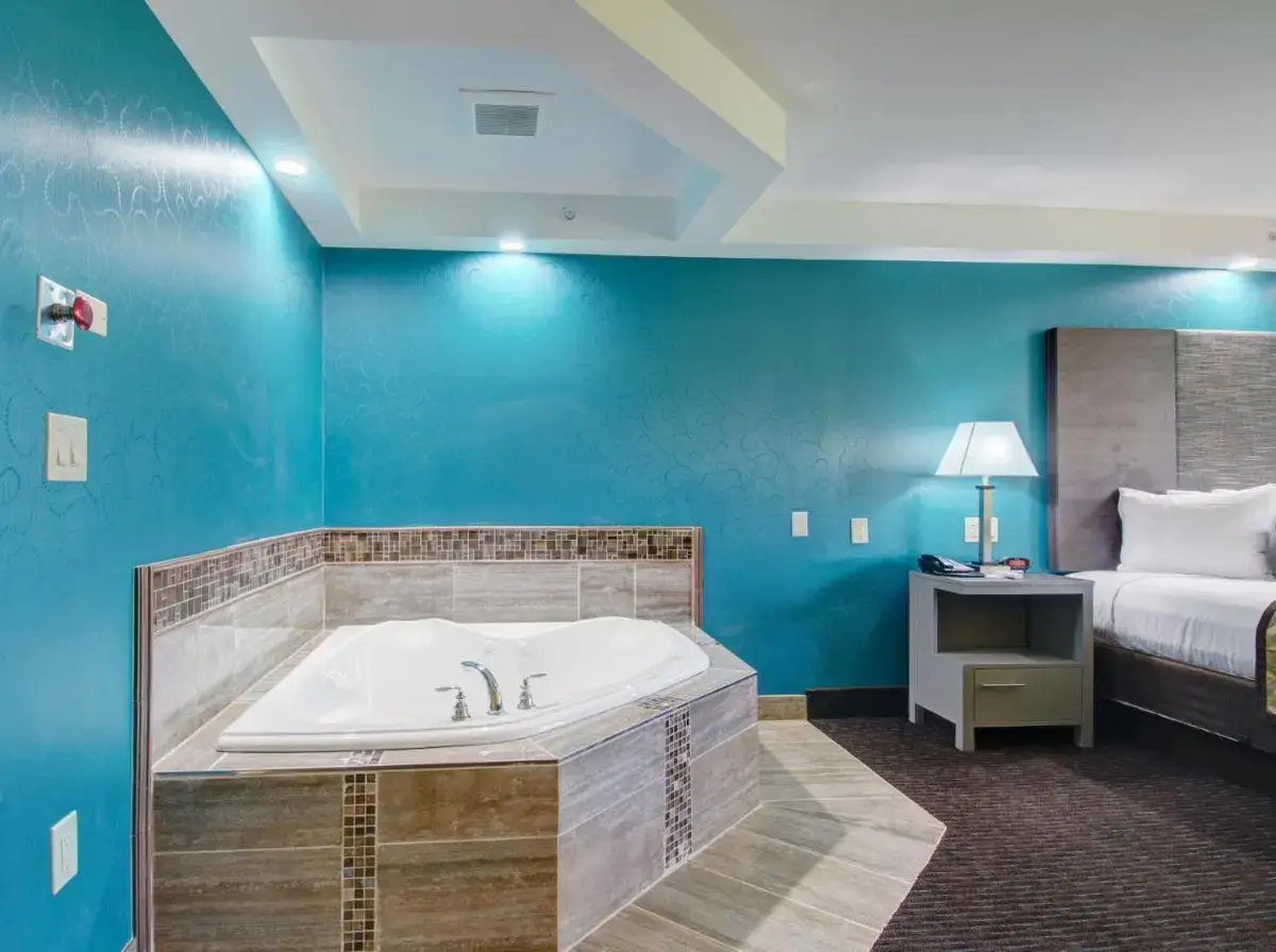 a large bathroom with a tub and a bed at Plymouth Bay Inn in Kingston