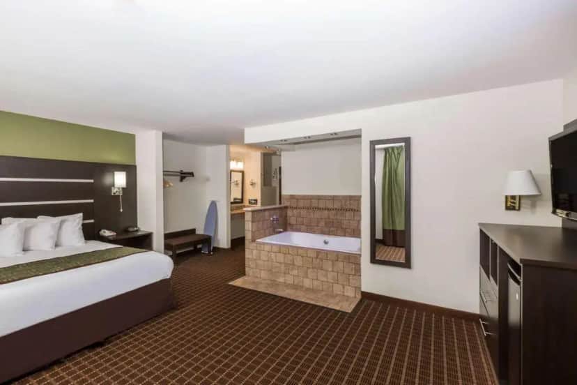 a hotel room with a bed and a bath tub at Baymont by Wyndham Louisville South/Shepherdsville/I 65 in Brooks