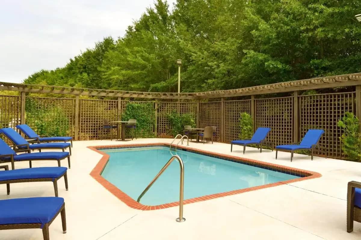 a swimming pool with blue chairs and chairs around it at Fairfield Inn & Suites by Marriott Anderson Clemson in Anderson