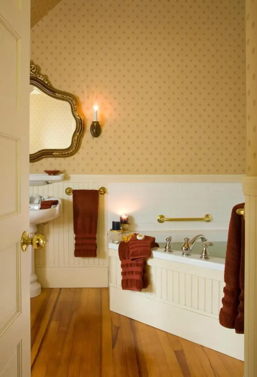 a bathroom with a tub and a sink and a mirror at Berry Manor Inn in Rockland
