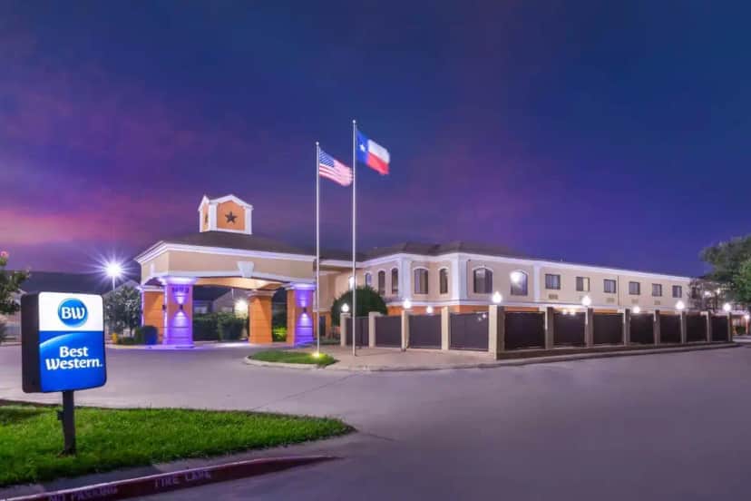 a building with two flags in front of it at night at Best Western Inn & Suites New Braunfels in New Braunfels
