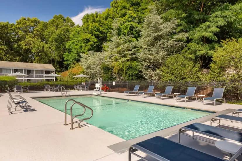 a swimming pool with chairs and a table at Best Western Plus Cold Spring in Plymouth