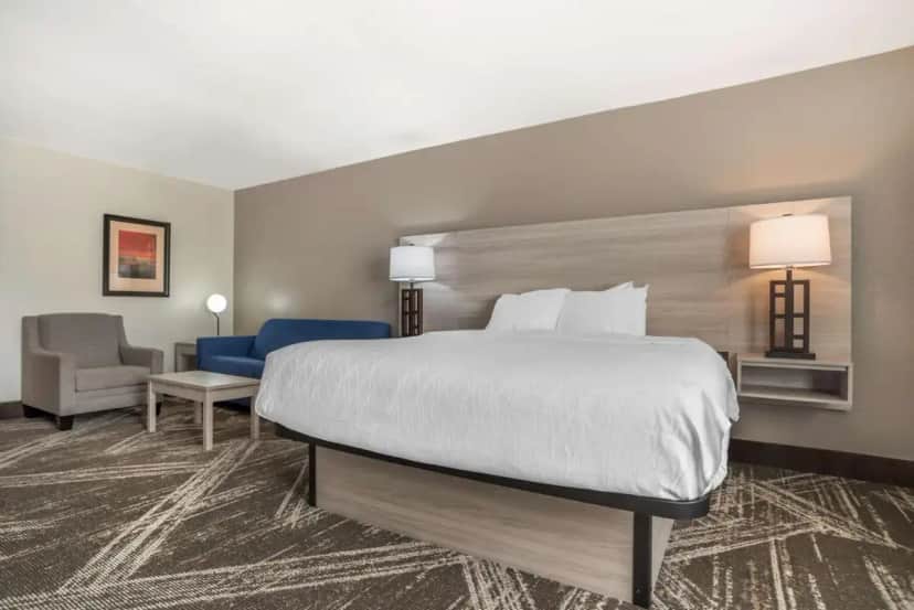 a hotel room with a large bed and a chair at Best Western Plus Jackson Downtown Coliseum in Jackson