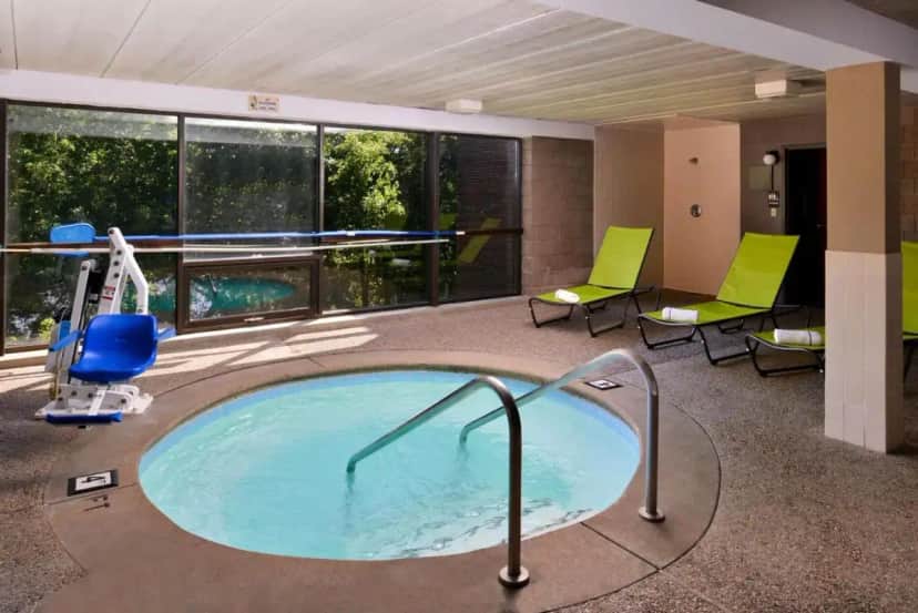 a jacuzzi tub in a hotel room with chairs at Best Western Plus Kelly Inn in Saint Cloud
