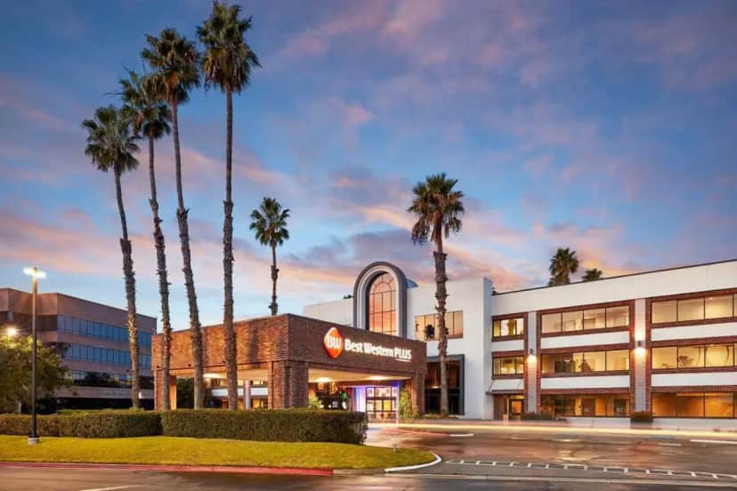a hotel with palm trees in front of a building at Best Western Plus Meridian Inn & Suites, Anaheim-Orange in Orange