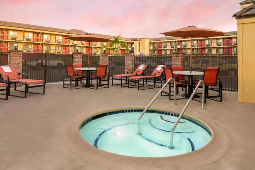 a hot tub on a patio with tables and chairs at Best Western Plus Raffles Inn & Suites in Anaheim