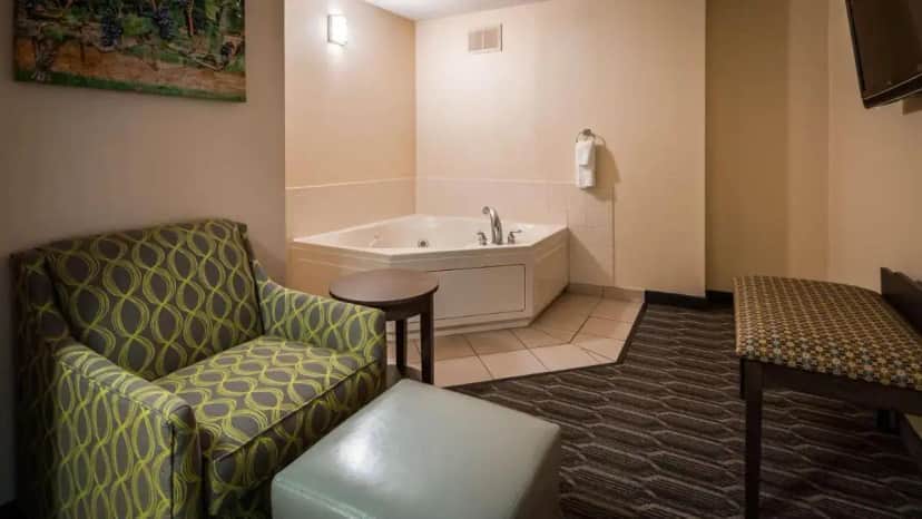 a bathroom with a couch and a tub and a chair at Best Western Plus Yadkin Valley Inn & Suites in Jonesville