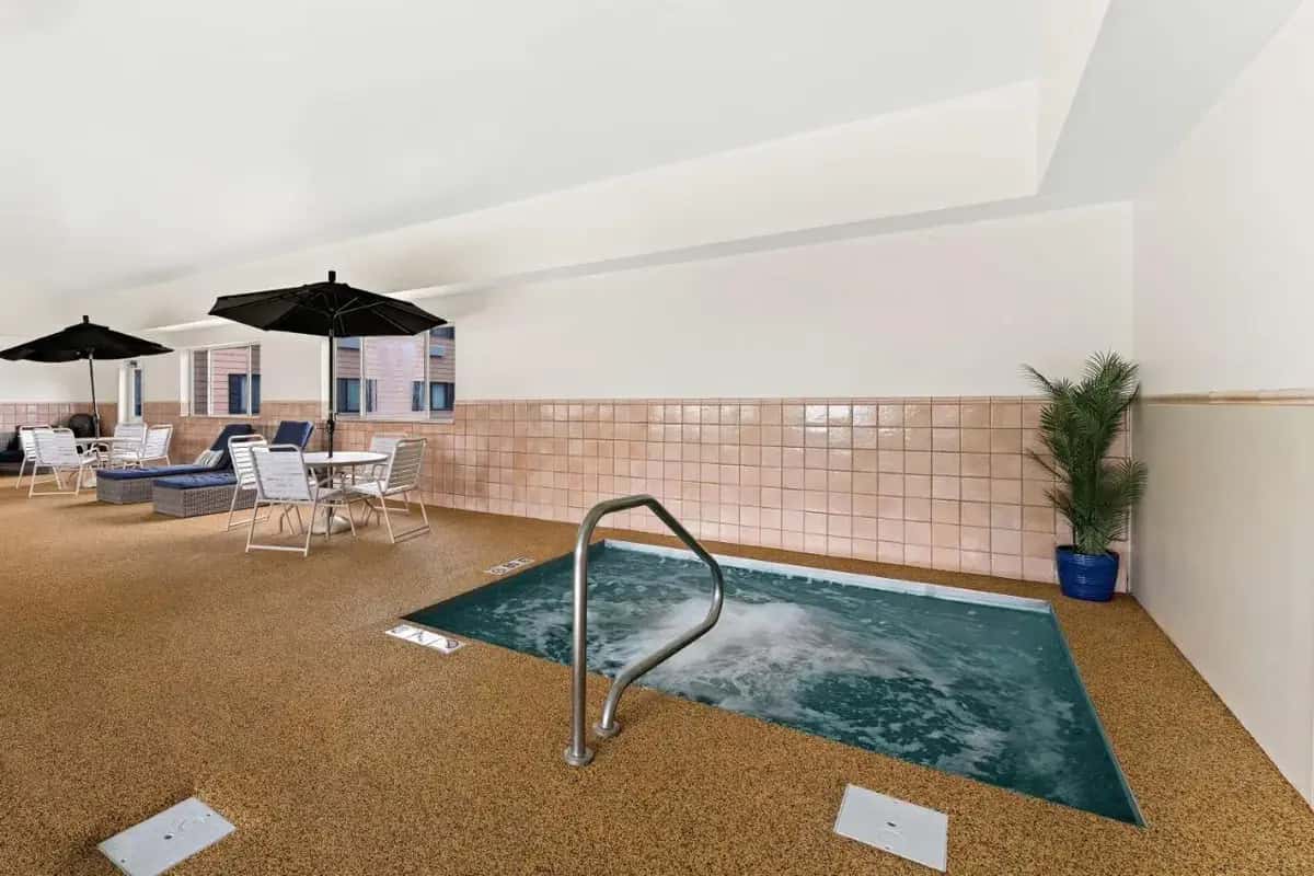 a hot tub in a room with tables and umbrellas at Best Western Vermillion Inn in Vermillion