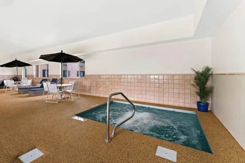 a hot tub in a room with tables and umbrellas at Best Western Vermillion Inn in Vermillion