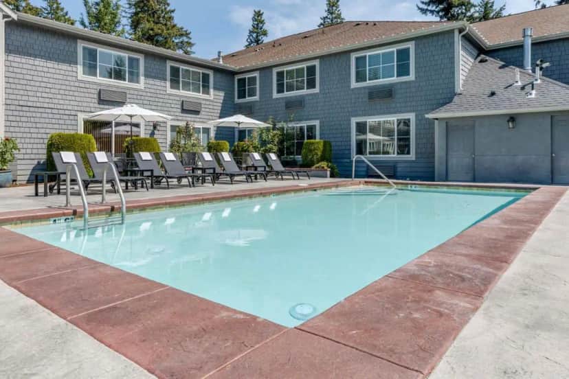 a swimming pool in front of a house at Best Western Wesley Inn & Suites in Gig Harbor