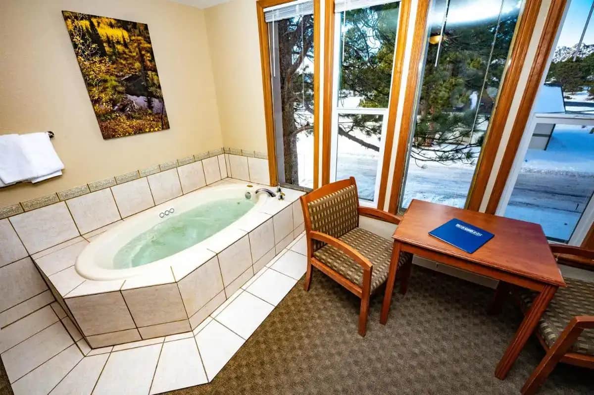 a jacuzzi tub in a room with a table at Blue Door Inn in Estes Park