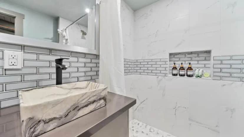a white bathroom with a marble sink and a tub at Blue Jay Lodge in South Lake Tahoe