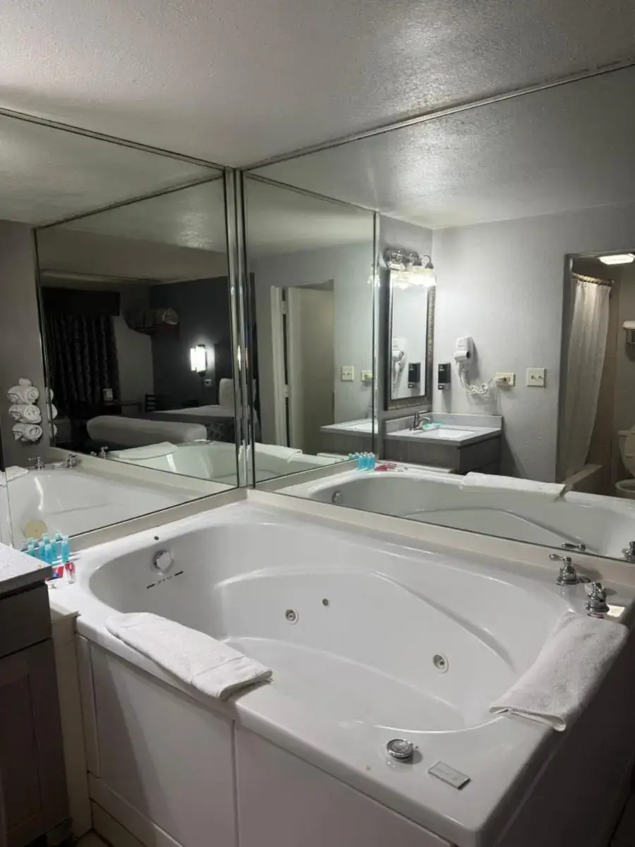 a large white bath tub with a large mirror at Blue Star Motel in Chicago Ridge