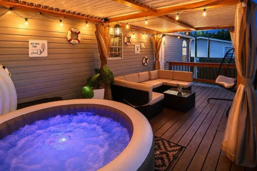 a jacuzzi tub on a deck with a couch at Book A Paradise with Jacuzzi, BBQ & Paddleboards in Fort Myers