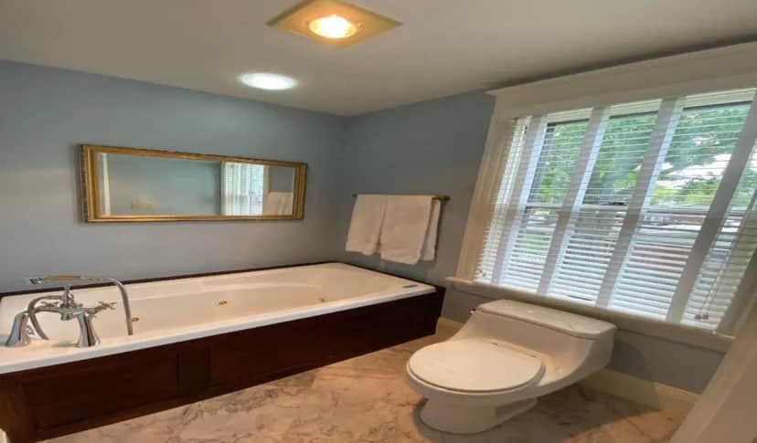 a bathroom with a tub and a toilet and a sink at Breese Inn in Breese