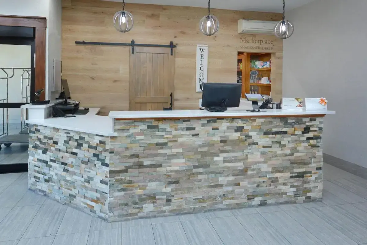 a lobby with a stone counter with a gmaxwell gmaxwell at Brookstone Lodge near Biltmore Village, an Ascend Collection Hotel in Asheville