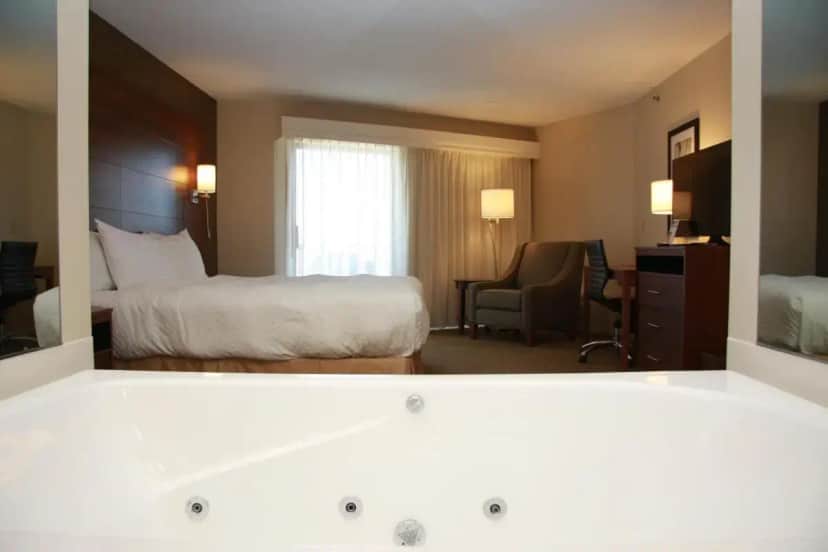 a hotel room with a bed and a desk at Budget Host Inn & Suites in Saint Ignace