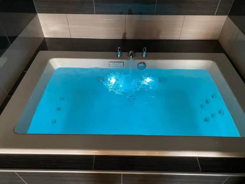 a large bath tub with blue water in it at Budget Inn in La Puente