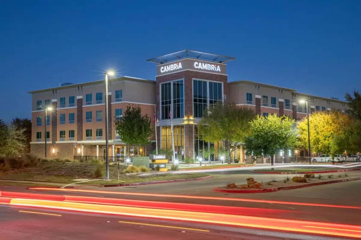 a building on a street at night with street lights at Cambria Hotel Plano - Frisco in Camey