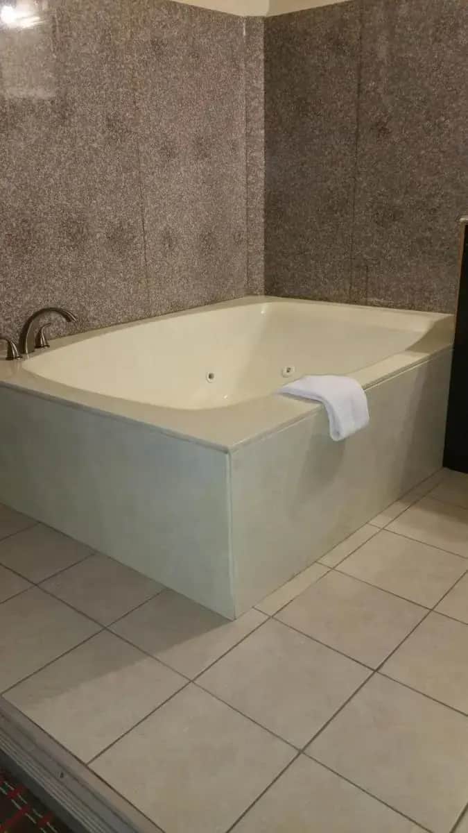 a bath tub in a bathroom with a towel on it at Capitol Inn and Suites in Montgomery
