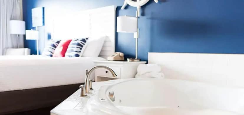 a bathroom with a white sink and a bed at Capt Thomson's Resort in Alexandria Bay