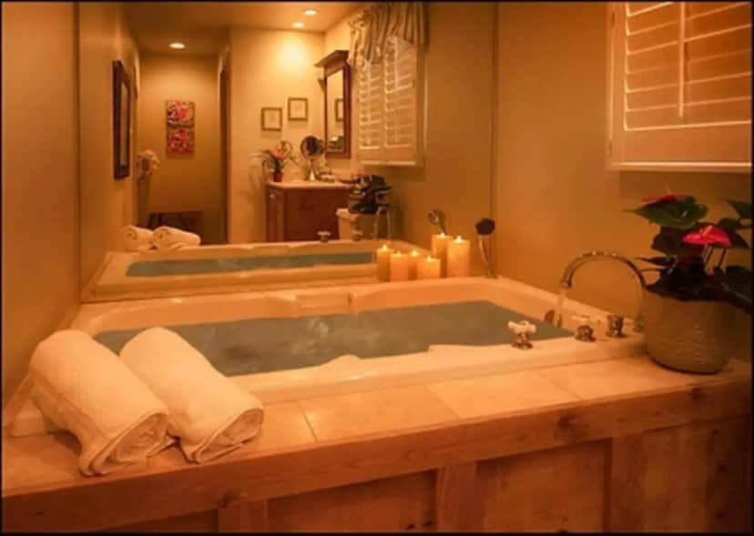 a bathroom with a large tub with candles in it at Carmel Country Inn in Carmel