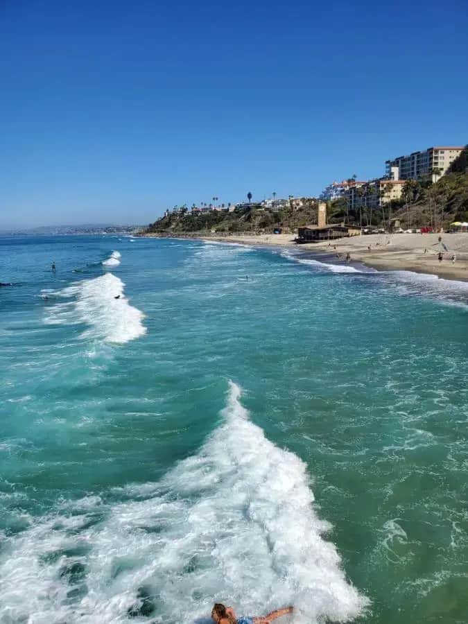 a person laying on the beach in the water at Casa Tropicana in San Clemente
