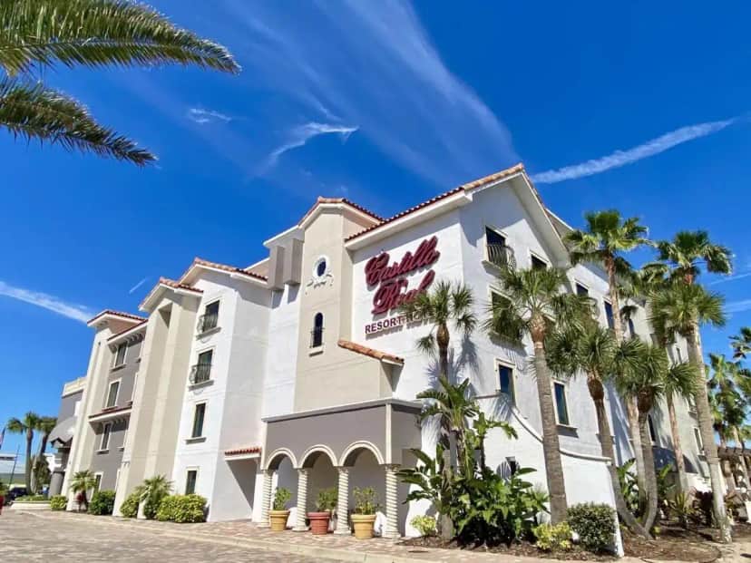 a large white building with palm trees in front of it