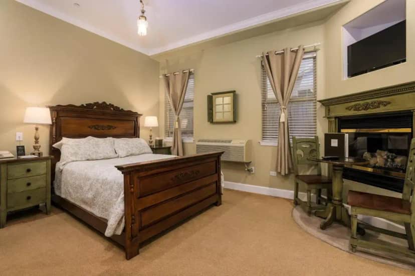 a bedroom with a bed and a desk and a piano at Cayucos Sunset Inn in Cayucos