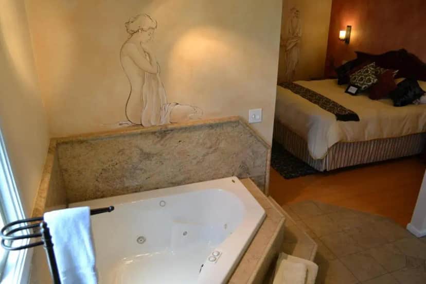 a bathroom with a tub with a statue of a woman at Chardonnay Lodge in Napa