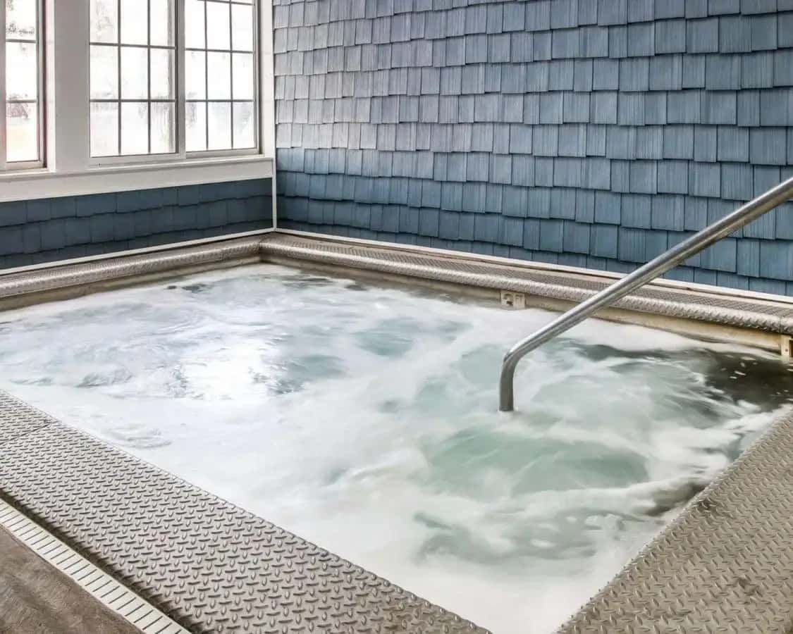 a jacuzzi tub in a blue tiled room at Clarion Hotel Mackinaw City Beachfront in Mackinaw City