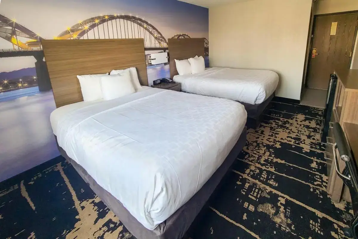 a hotel room with two beds with white sheets at Clarion Pointe Bettendorf - Quad Cities in Bettendorf