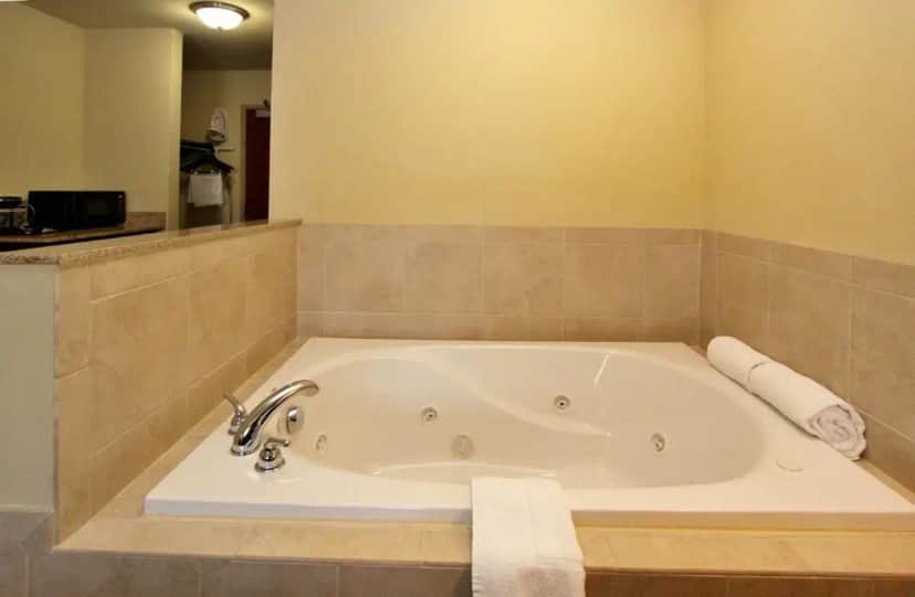 a bath tub in a bathroom with a sink at Cobblestone Inn & Suites-Fremont in Fremont