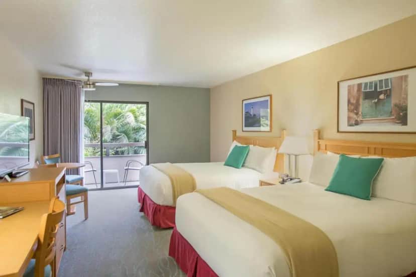 a hotel room with two beds and a desk at Colton Inn in Monterey