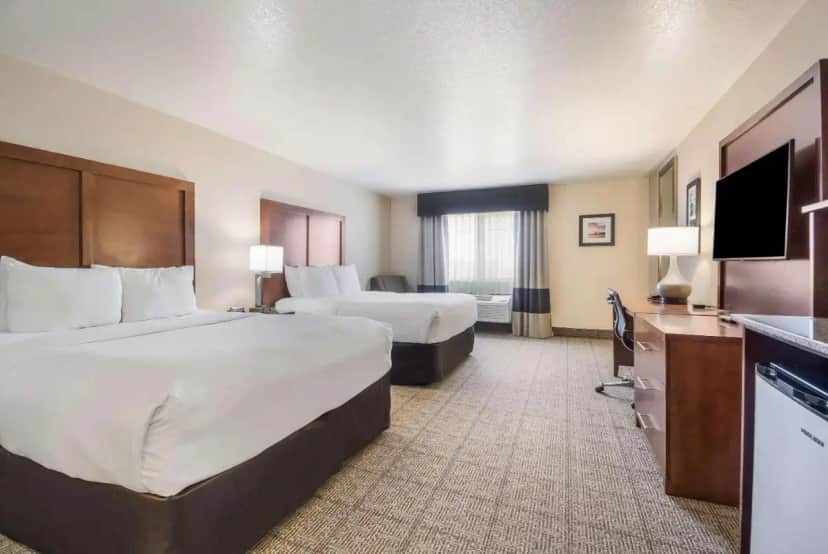 a hotel room with two beds and a flat screen tv at Comfort Inn Newport in Newport
